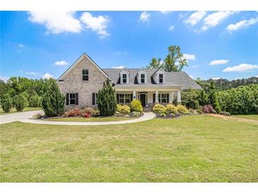 Charming brick home featuring a well-manicured lawn, mature trees, and a welcoming front porch at 122 Gingers Way, Mcdonough, GA 30252