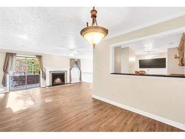 Bright living room featuring wood floors, a fireplace, and sliding glass doors leading to a balcony at 1482 N Crossing Ne Cir, Atlanta, GA 30329