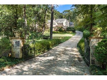 Long stone driveway leading to a beautiful home surrounded by mature trees and lush landscaping at 4375 Mount Paran Pkwy Nw, Atlanta, GA 30327