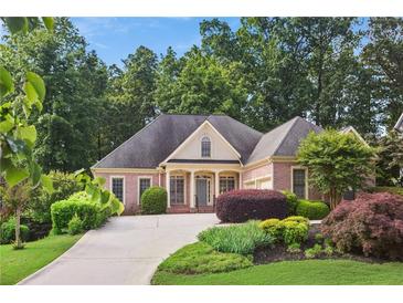 Charming brick home boasts a well-manicured front yard with lush landscaping and a welcoming driveway at 980 Ector Chase Nw, Kennesaw, GA 30152