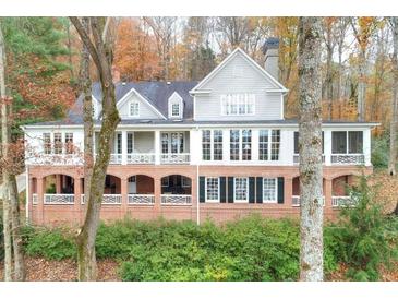 Stately two-story home featuring a brick foundation and multi-paned windows, surrounded by fall foliage at 130 River Ne Lndg, Sandy Springs, GA 30350