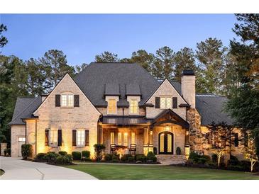 Stunning brick home featuring a beautifully landscaped front yard, elegant entrance, and meticulously maintained architecture at 670 Trinity Pl, Suwanee, GA 30024