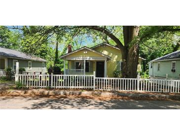 Charming cottage-style home featuring a picket fence, covered porch, and mature trees at 1162 Sims St, Atlanta, GA 30310