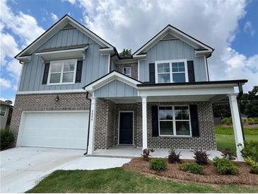 Charming two-story home featuring a brick and siding exterior with black shutters, a covered entrance and a two-car garage at 3064 Steinbeck Way, Atlanta, GA 30344