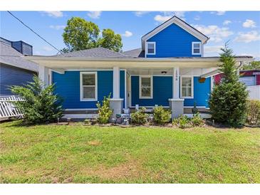 Charming two-story home with a blue exterior, inviting front porch, and well-manicured lawn at 1598 Jonesboro Se Rd, Atlanta, GA 30315