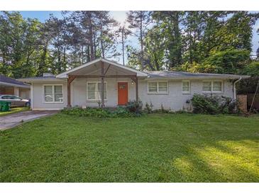 Charming single-story home featuring a well-maintained lawn and inviting orange front door at 1909 Cindy Dr, Decatur, GA 30032