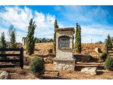Community entrance sign, 'The Enclave at Azalea Hills', with landscaping and a glimpse of the neighborhood homes at 231 Ivey Ter, Temple, GA 30179