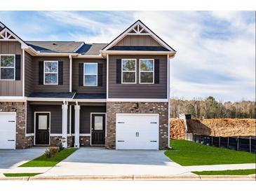 Beautiful townhome featuring a brick facade, a single-car garage and a well manicured lawn at 231 Ivey Ter, Temple, GA 30179