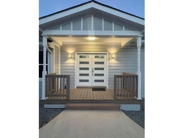 Inviting front entrance featuring double doors, a covered porch, and decorative lighting creating a warm and welcoming ambiance at 9058 Woodlake Lane, Villa Rica, GA 30180