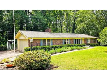 Charming single-story brick home featuring a well-manicured lawn and lovely landscaping at 1110 Blackwell Rd, Marietta, GA 30066