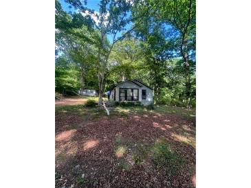 View of the home's exterior, showing the yard and surrounding mature trees at 2700 Snapfinger Rd, Decatur, GA 30034