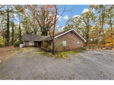 Brick home with mature trees, driveway, and landscaping at 2775 Hogan Rd, Atlanta, GA 30344