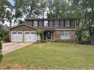 Two-story home with stone and siding, two-car garage, and a well-manicured front lawn at 1055 Worthington Hills Dr, Roswell, GA 30076