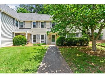 Charming two-story townhouse featuring a well-maintained lawn, mature trees, and neutral-toned siding at 4131 N Gloucester Pl, Atlanta, GA 30341