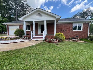 Charming brick home featuring a well-manicured lawn and inviting front porch at 126 Brittany Dr, Canton, GA 30115