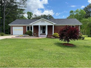 Charming one-story brick home with well-manicured lawn and mature landscaping at 126 Brittany Dr, Canton, GA 30115