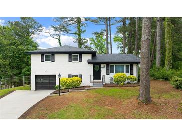 Charming white brick home with a well-manicured lawn and an attached garage at 1934 Glen Echo Dr, Decatur, GA 30032
