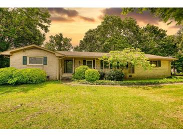 Charming ranch home with a spacious front yard and mature trees, creating a serene and inviting curb appeal at 2368 Ellis Court, Snellville, GA 30078