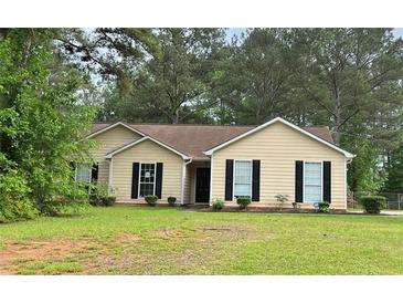 Charming single-story home featuring manicured lawn and classic curb appeal with mature trees at 432 Manor Estates Dr, Stockbridge, GA 30281
