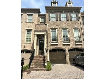 Charming brick townhome with front-entry garage and well-maintained landscaping at 9056 Riverbend Mnr, Alpharetta, GA 30022