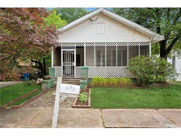 Charming white home with a screened porch and well-maintained front yard at 1792 Center Ave, East Point, GA 30344