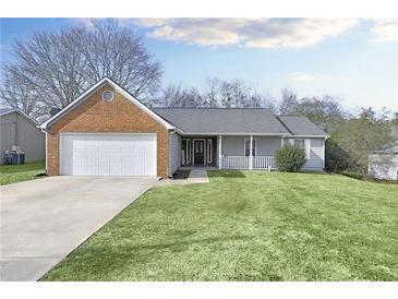 Charming single Gathering home featuring an attached two car garage and well-manicured front lawn at 6057 Dorchester Dr, Rex, GA 30273