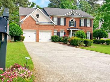 Charming two-story brick home featuring a two-car garage and a well-manicured front yard with lush landscaping at 2049 Mclain Nw Rd, Acworth, GA 30101