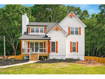 Charming home with orange shutters, a well-manicured lawn, and a cozy front porch at 77 Township Drive, Hiram, GA 30141
