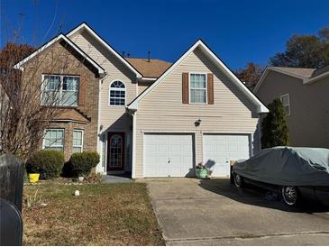 Charming two-story home boasts a two-car garage and a mix of brick and siding accents at 11631 Kades Trl, Hampton, GA 30228