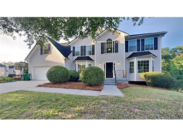 Charming two-story home with dark shutters, landscaped yard and attached two car garage at 2352 Benson Rdg, Lithonia, GA 30058