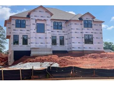 Construction of a new two-story home with architectural details and window installations in a landscaped community at 3066 Reserve Ct Sw, Conyers, GA 30094