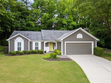 Charming one-story home with a well-maintained lawn, yellow door, and an attached two-car garage at 245 Scotch Pine Ct, Alpharetta, GA 30022