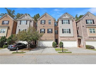 Charming townhomes featuring brick and neutral siding, attached garages, and manicured landscaping at 2173 Pebble Beach Dr, Lawrenceville, GA 30043
