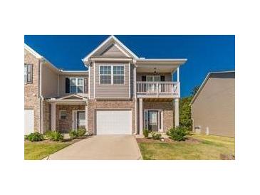 Charming townhome boasts a covered porch and attached garage at 7162 Fringe Flower Dr, Austell, GA 30168