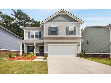 Charming two-story home with a gray exterior, covered porch, and two-car garage at 9007 Jim Purcell Dr, Covington, GA 30014