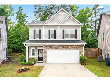 Charming two-story home with stone accents, a two-car garage, and manicured landscaping at 2939 Woodward Down Trl, Buford, GA 30519