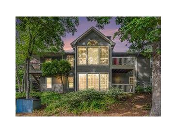 Charming two-story home with multiple windows and balconies surrounded by mature trees and lush landscaping at 2105 Country Park Se Dr, Smyrna, GA 30080