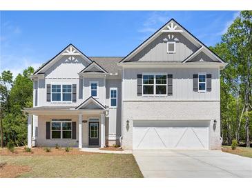 Beautiful two-story home boasts a brick and siding exterior, attached two-car garage, and well-manicured front yard at 2749 Porches Ln, Dacula, GA 30019