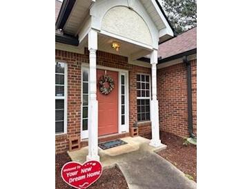 Welcoming brick home featuring a covered entryway and lovely front door wreath at 300 Gaelic Way, Tyrone, GA 30290