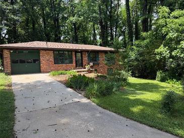 Charming brick home with a well-maintained lawn and attached garage at 1094 Seville Dr, Clarkston, GA 30021