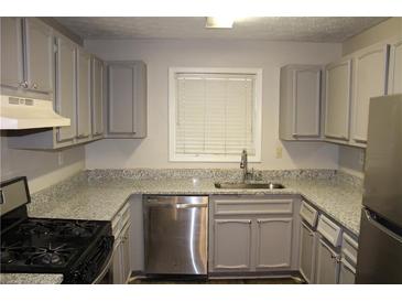 The kitchen features stainless steel appliances and gray cabinets at 1105 Natchez Trce, Atlanta, GA 30350