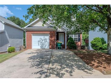 Charming brick home with a one-car garage and driveway, complemented by mature landscaping at 152 Stoneforest Dr, Woodstock, GA 30189