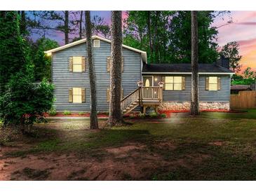 Charming two-story home with wood siding, shutters, stone foundation, and a cozy front porch with beautiful yard at 256 Grist Mill Ln, Lawrenceville, GA 30046