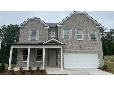 Charming two-story brick home with a welcoming front porch and a two-car garage at 3100 Steinbeck Way, Atlanta, GA 30344