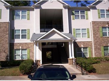 A three story apartment building with brick accents, green shutters, and manicured shrubbery at 3201 Fairington Dr, Lithonia, GA 30038