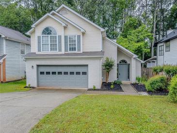 Charming two-story home featuring a gray garage door, a well-manicured lawn, and fresh landscaping at 1265 Watercrest Cir, Lawrenceville, GA 30043