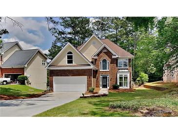Charming two-story brick home with landscaped front yard and attached two car garage at 6845 Gledhill Way, Stone Mountain, GA 30087