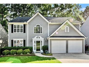 Charming two-story home with gray siding, black shutters, two-car garage and beautifully manicured lawn at 4311 Sentinel Nw Pl, Kennesaw, GA 30144