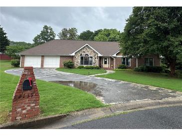 Charming single-story brick home featuring a stone accent, two-car garage, and well-manicured front yard at 2139 Bramlett Nw Pl, Marietta, GA 30064