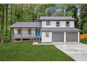Charming two-story home featuring a well-manicured lawn, a two-car garage, and a welcoming blue front door at 798 Brownlee Ln, Lawrenceville, GA 30044